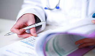 Physician holding a pen and medical chart