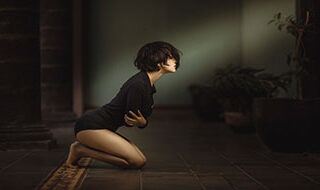 woman on knees in pain