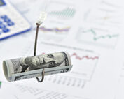 a one hundred dollar bill rolled up on a fish hook