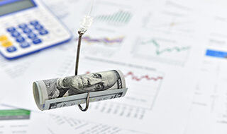 a one hundred dollar bill rolled up on a fish hook