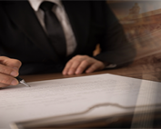 an attorney at a desk signing documents