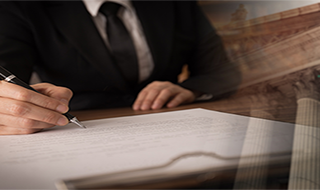 an attorney at a desk signing documents