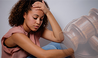 a woman stressed out with her hand on her head. a gavel in the background
