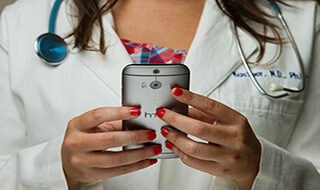 female doctor holding cell phone